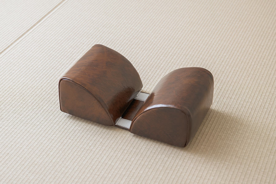 畳の上に置かれた、手技整体で使う茶色い枕