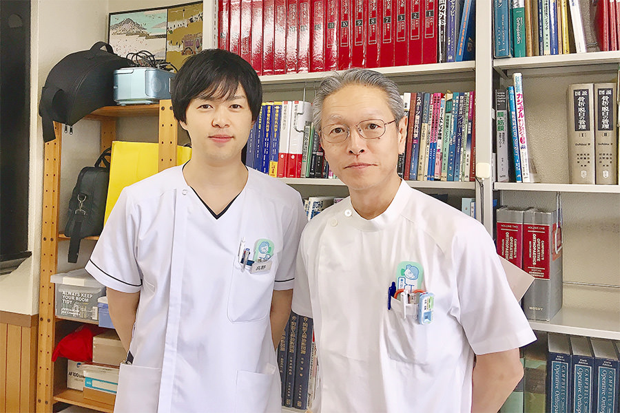 勤務していた整形外科で、医学書の並ぶ書棚を背に栗原院長と並ぶ院長