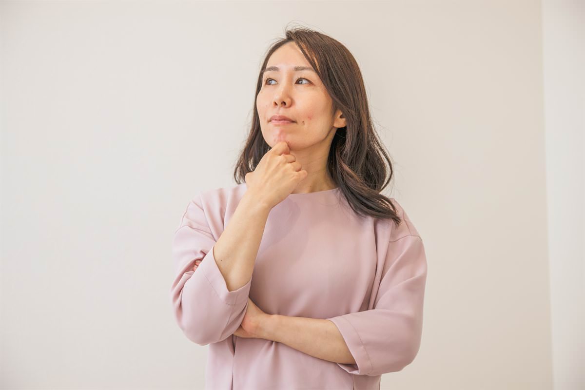 あごに手を当てて考え込む女性