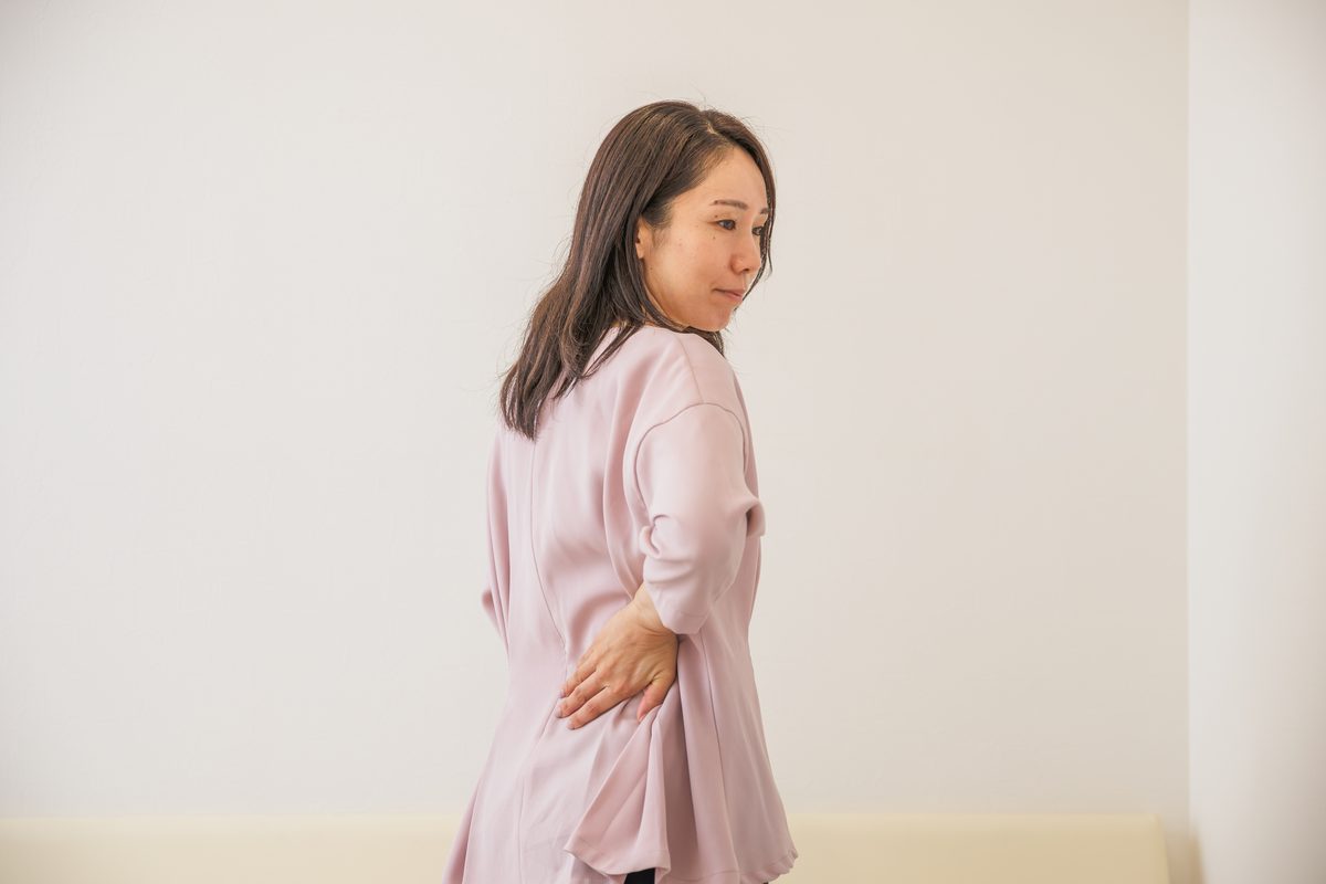振り返るように体をひねり、片手を腰に当てる女性